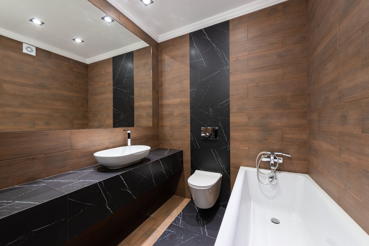 Salle de bain moderne avec vasque, baignoire et WC suspendu installés par Plombier Waterloo