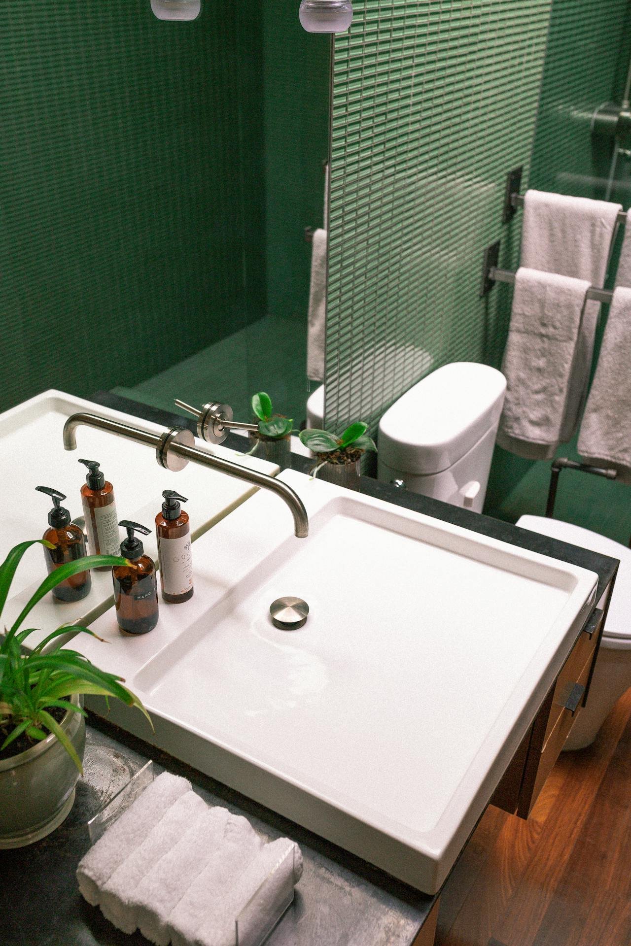 Lavabo et robinetterie murale dans une salle de bain rénovée par Plombier Waterloo
